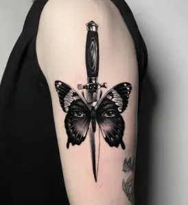 Butterfly face and dagger tattoo