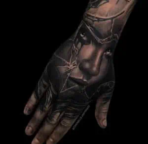 Womans face tattoo on a hand