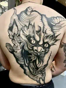 Devils face back piece engraving tattoo